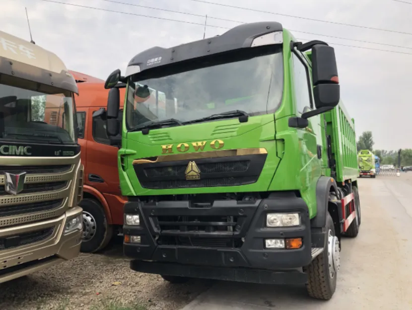 Front view of a bright green HOWO dump truck parked outdoors