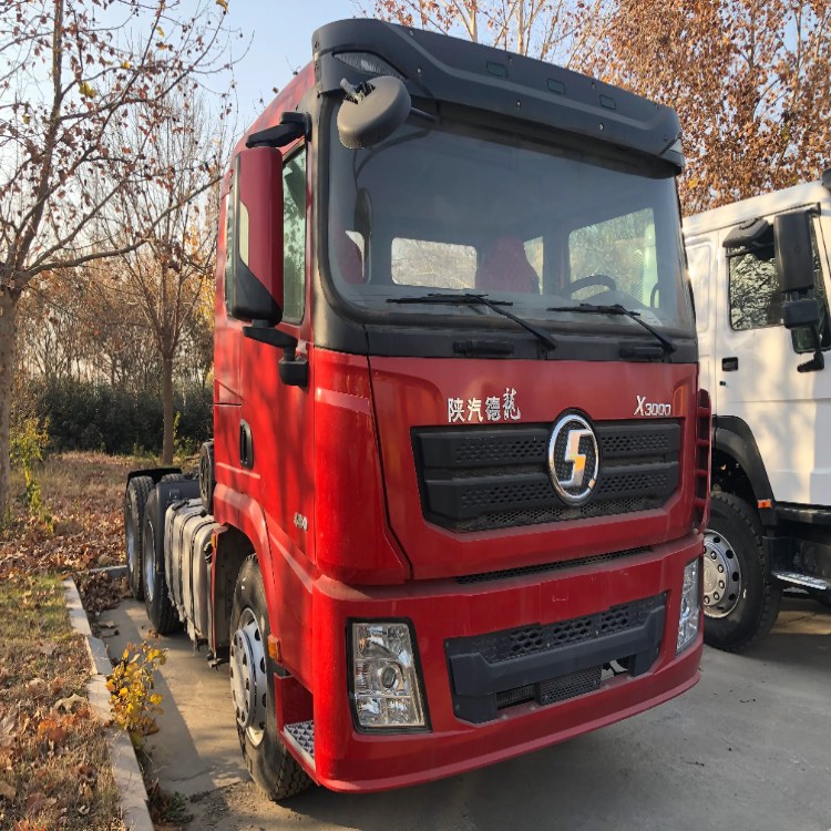 Front view of a red SHACMAN X3000 heavy-duty tractor truck parked outdoors